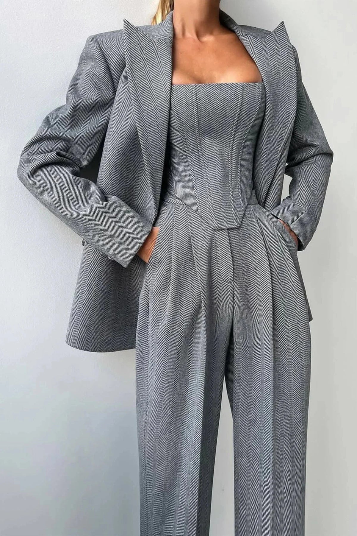 Ensemble femme trois pièces gris avec haut ajusté en tissu léger et respirant, au design élégant.