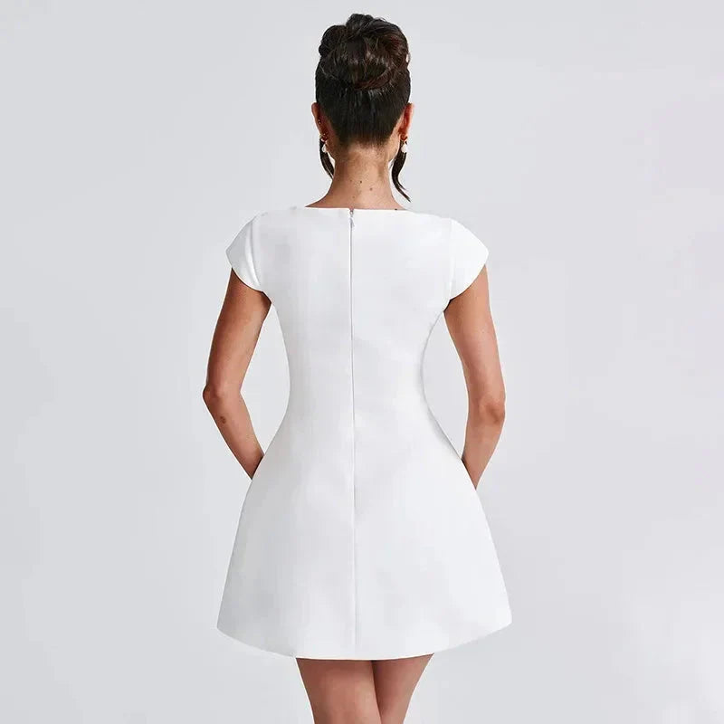 Robe courte blanche en coton avec encolure carrée et manches courtes, silhouette ajustée pour soirée élégante.