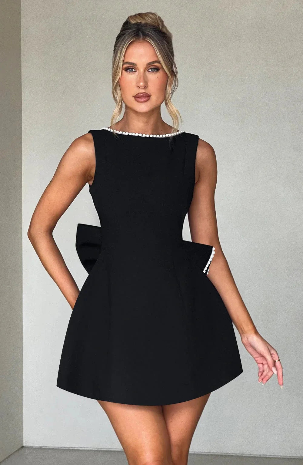 Robe courte femme en coton léger, avec nœud décoratif au dos et coupe ajustée pour un style élégant et décontracté.