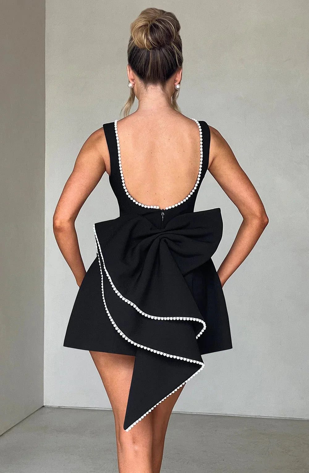 Robe courte femme en coton avec nœud décoratif au dos et manches courtes, idéale pour les journées ensoleillées.