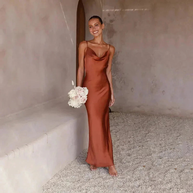 Robe longue sans manches en satin, col bénitier élégant, disponible en plusieurs couleurs. Parfaite pour les occasions…