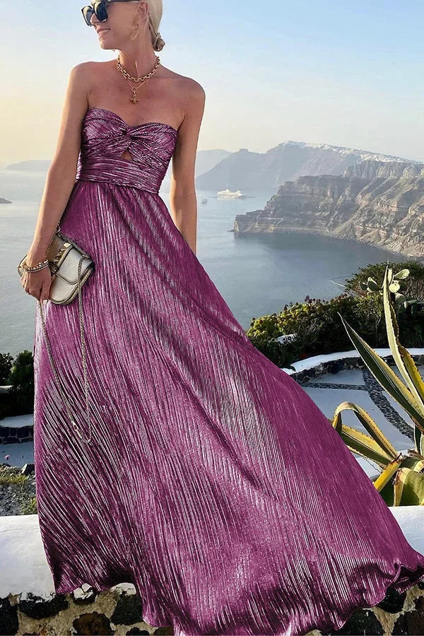 Robe longue bustier à effet brillant, en tissu fluide, avec nœud élégant sur une silhouette longiline et féminine pour soirée.