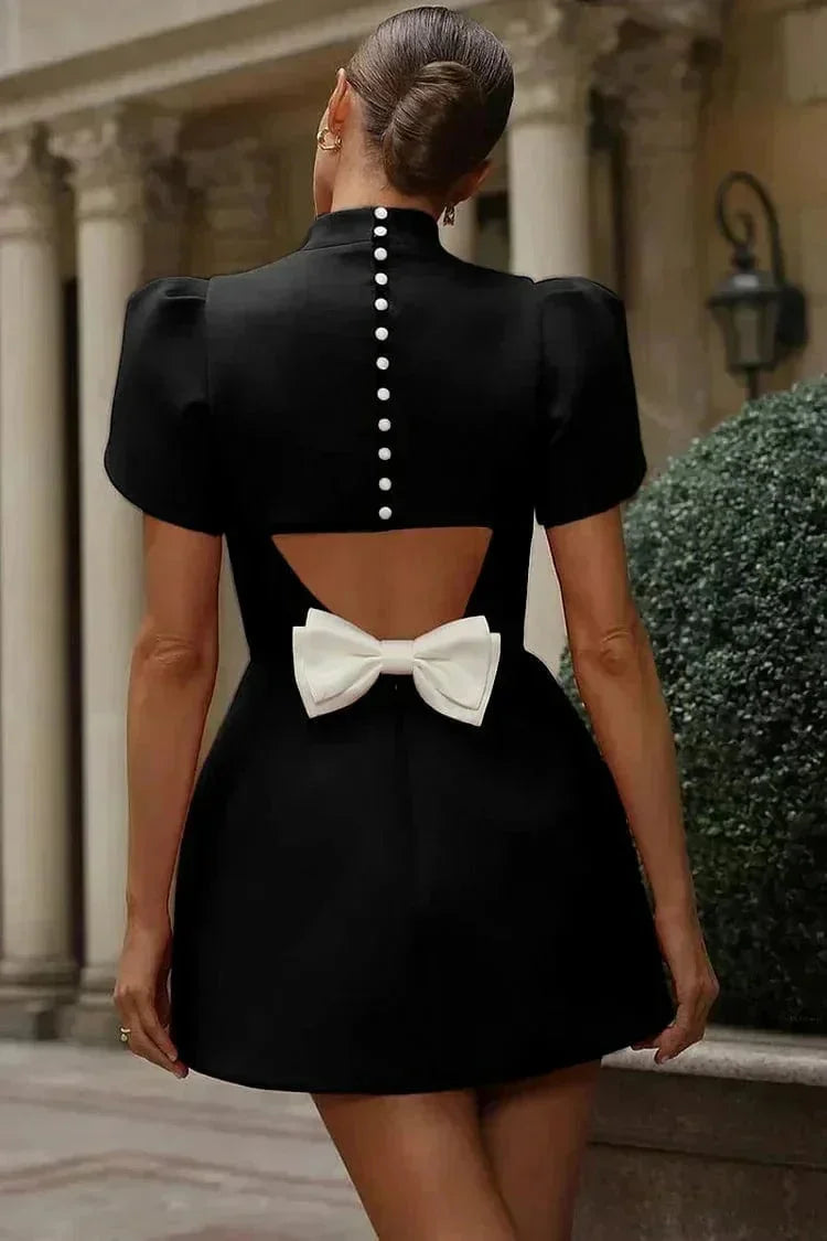 Robe courte ajustée avec manches structurées, en tissu uni, ornée de ruffles, idéale pour des cocktails élégants.