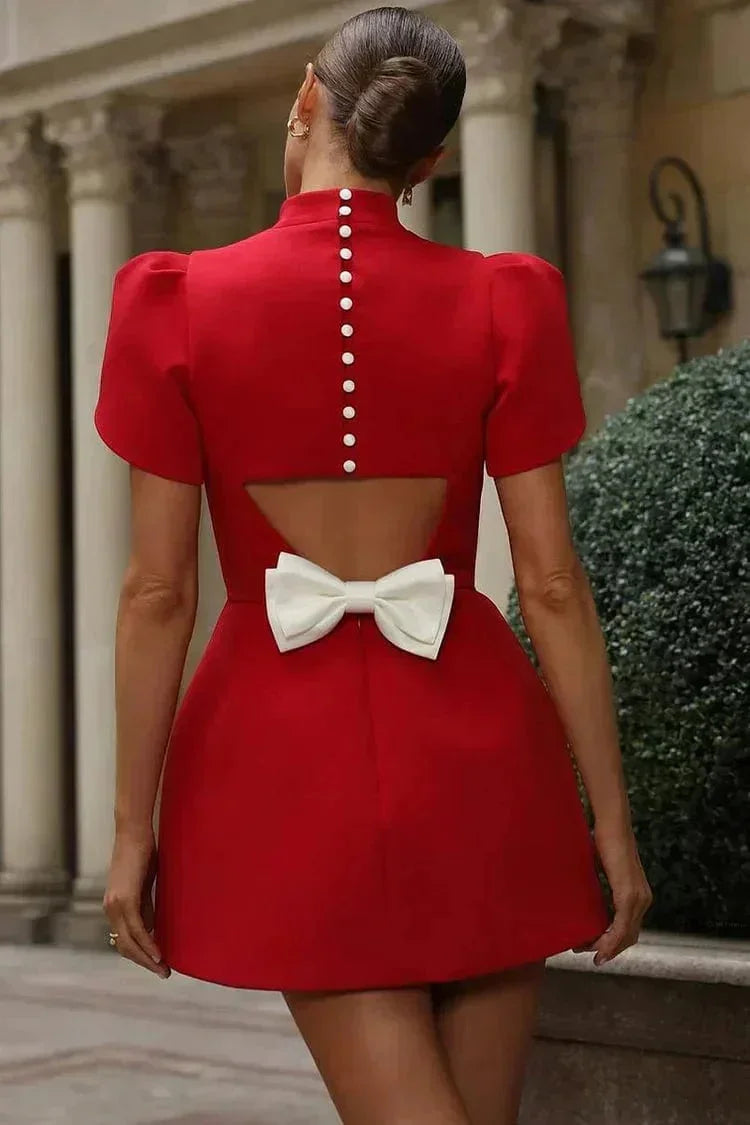 Robe courte ajustée avec manches structurées en tissu uni, détails de ruffles, idéale pour les cocktails.