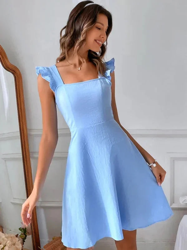 Robe courte évasée sans manches, en coton léger, avec volants et bretelles, idéale pour les journées estivales.