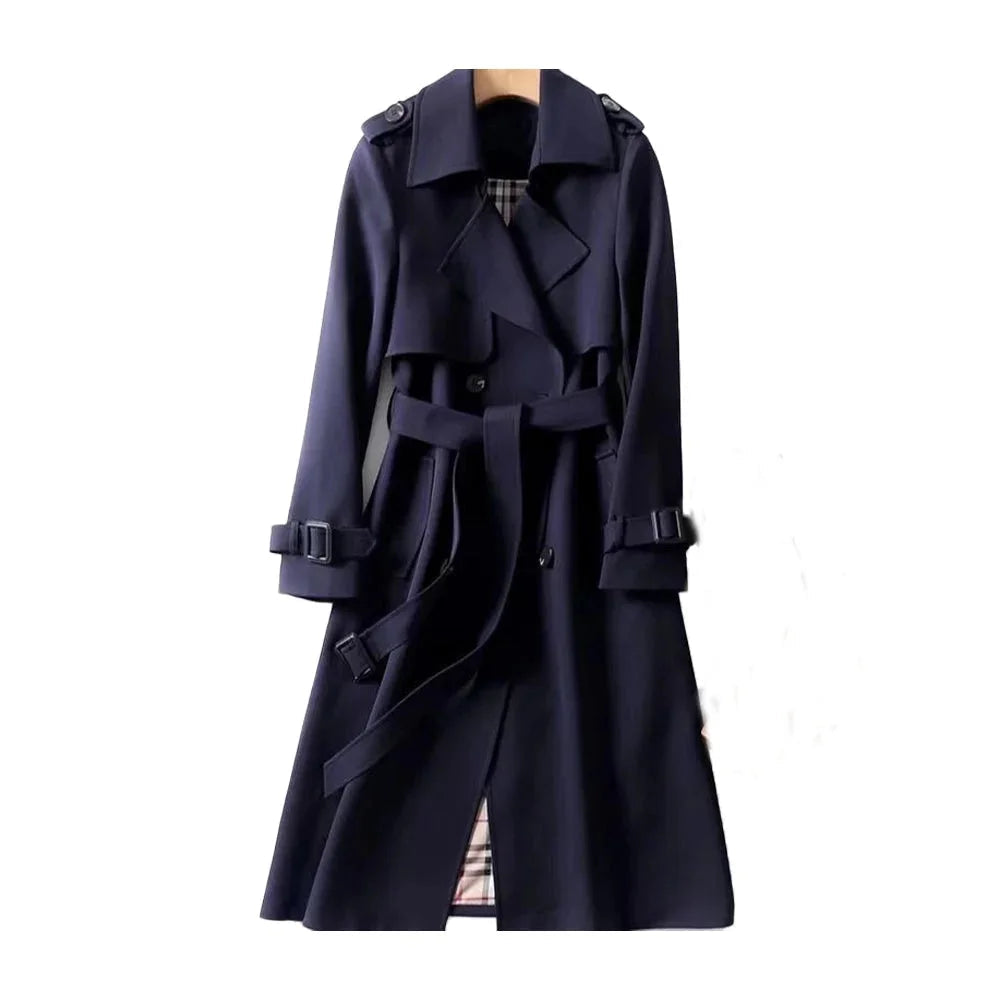 Trench-coat long beige pour femme, ceinturé, avec revers et en tissu léger et résistant aux intempéries.
