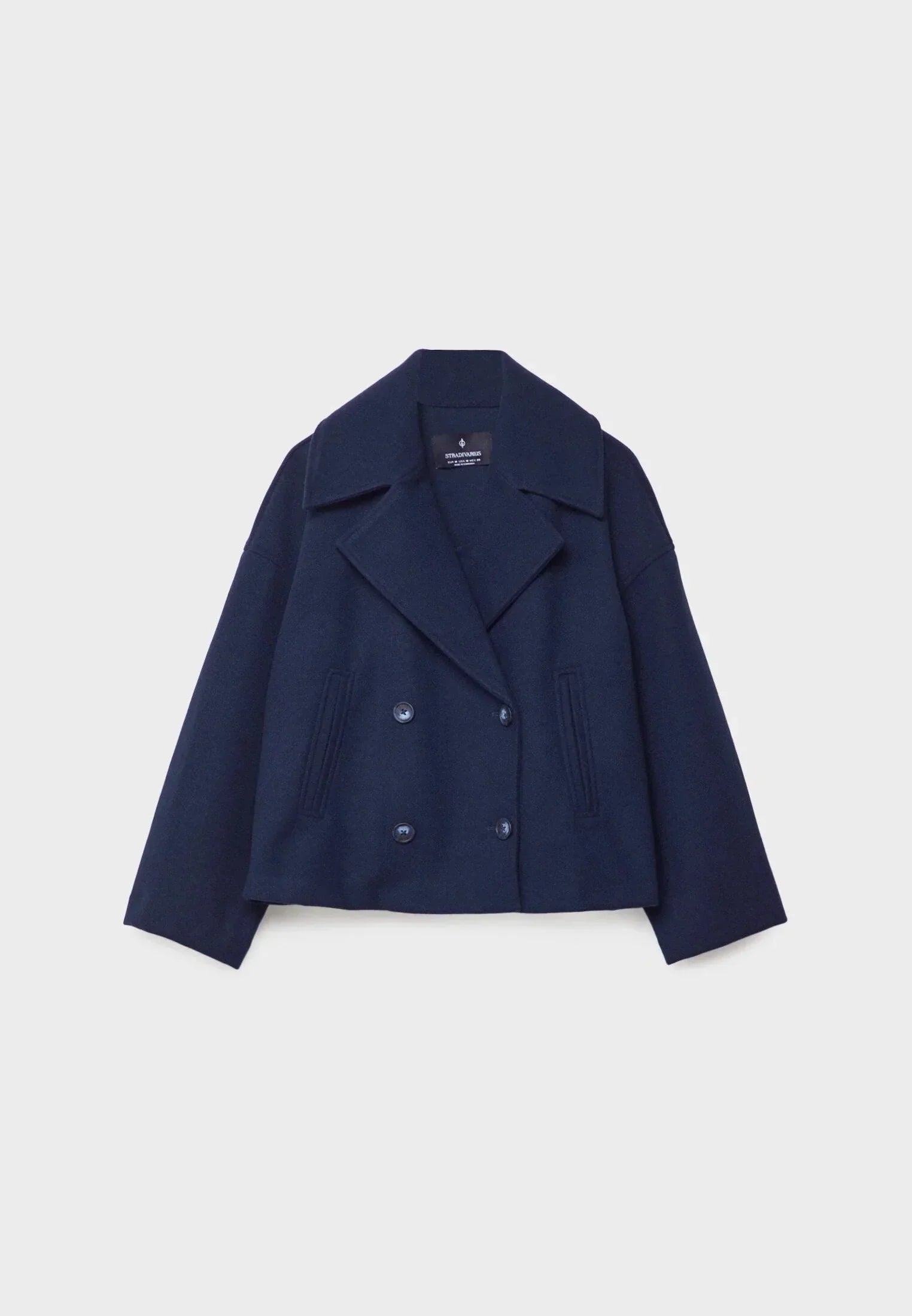 Veste femme courte beige à double boutonnage, en tissu doux et résistant, avec une coupe élégante.