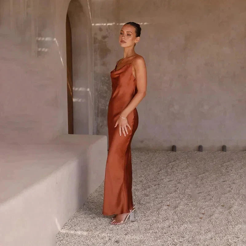 Robe longue sans manches en satin avec col bénitier, disponible en plusieurs couleurs, idéale pour les occasions spéciales.